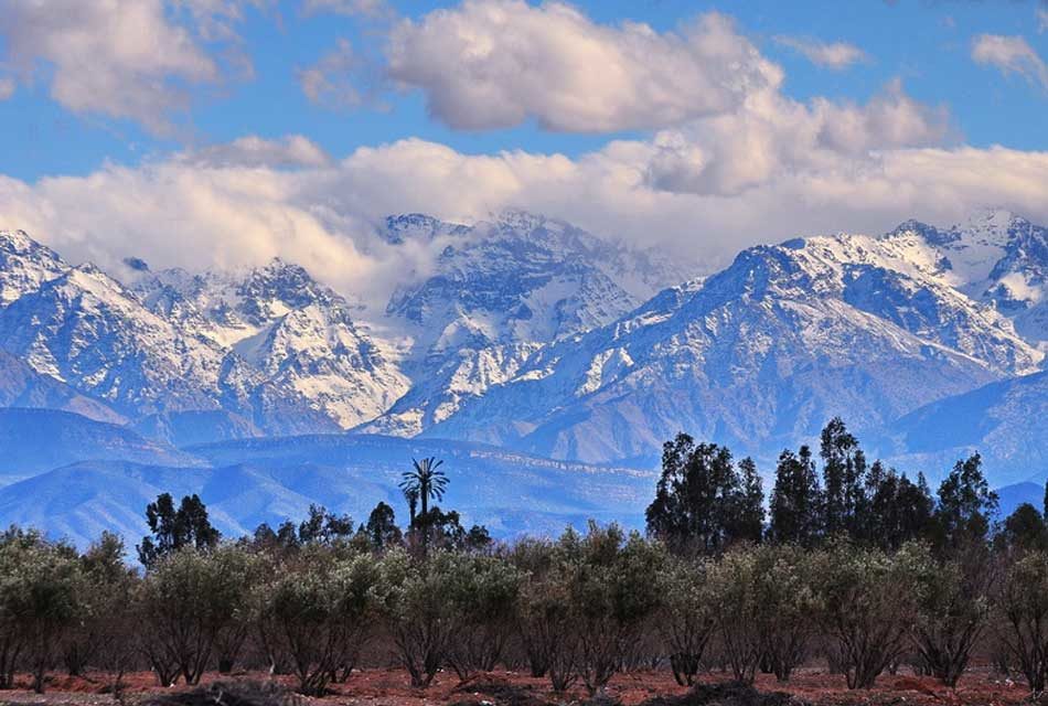 Snow-capped High Atlas peaks rising behind a Berber village near Marrakech